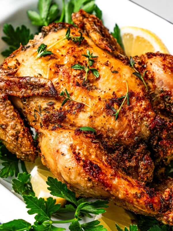 Breast-view of air fryer cornish game hen on a bed of fresh parsley.