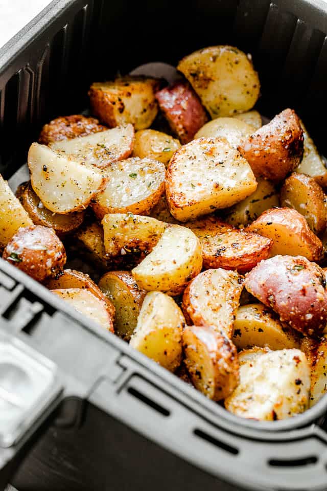 halved potatoes in an air fryer basket