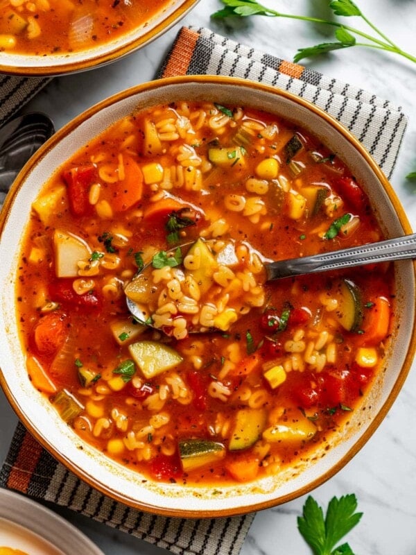 Overhead image of a spoon dipping into a bowl of alphabet soup.