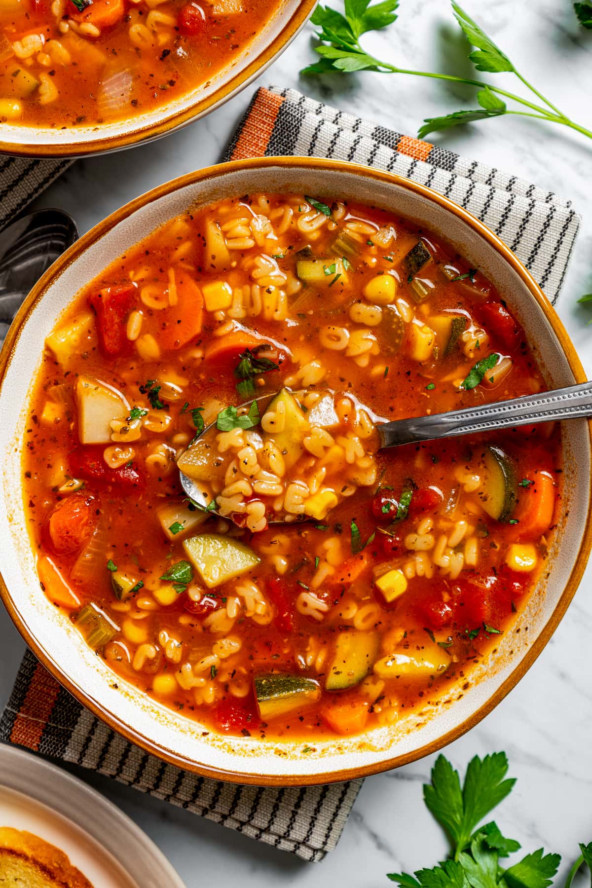 Overhead image of a spoon dipping into a bowl of alphabet soup.