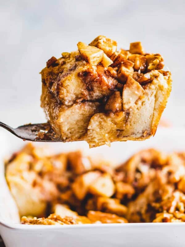 Spoonful of apple cinnamon French toast bake held up by a large spoon.