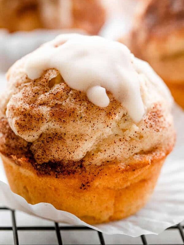 Close up shot of a glazed apple muffin set on a black wire rack.