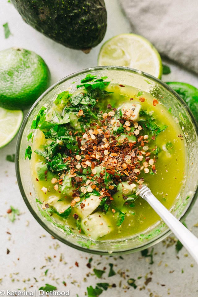 Combining the ingredients for avocado chimichurri sauce in a blender.