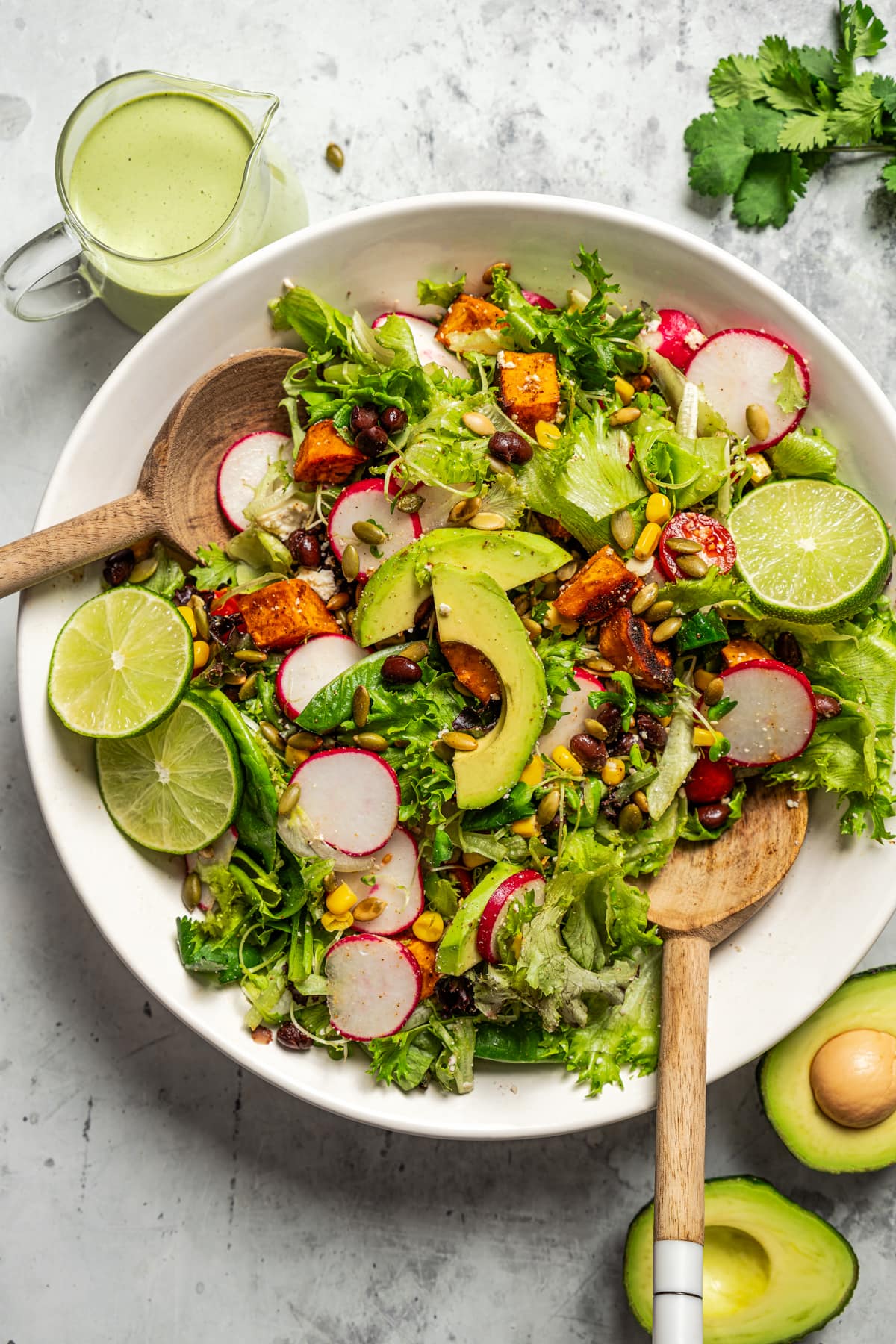 Tossing a salad with avocado lime ranch dressing.