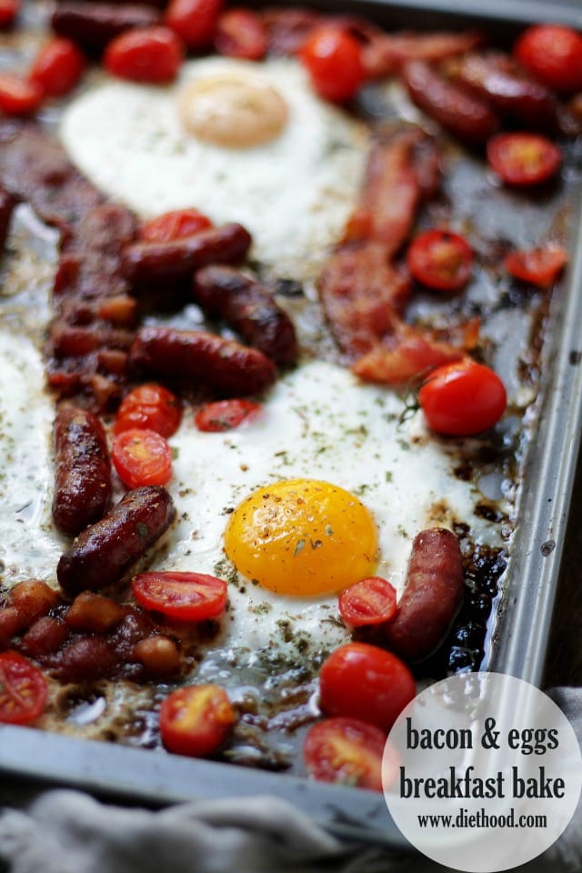 Eggs, bacon, sausage, and tomatoes on a baking sheet.