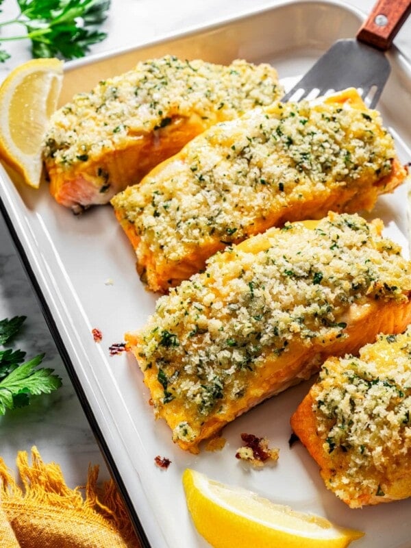 Honey mustard salmon fillets crusted with panko breadcrumbs on a baking sheet.