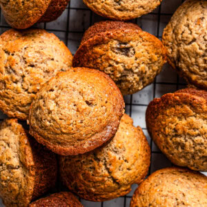 A bunch of banana muffins on a cooling rack.