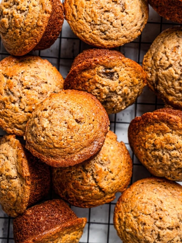 A bunch of banana muffins on a cooling rack.