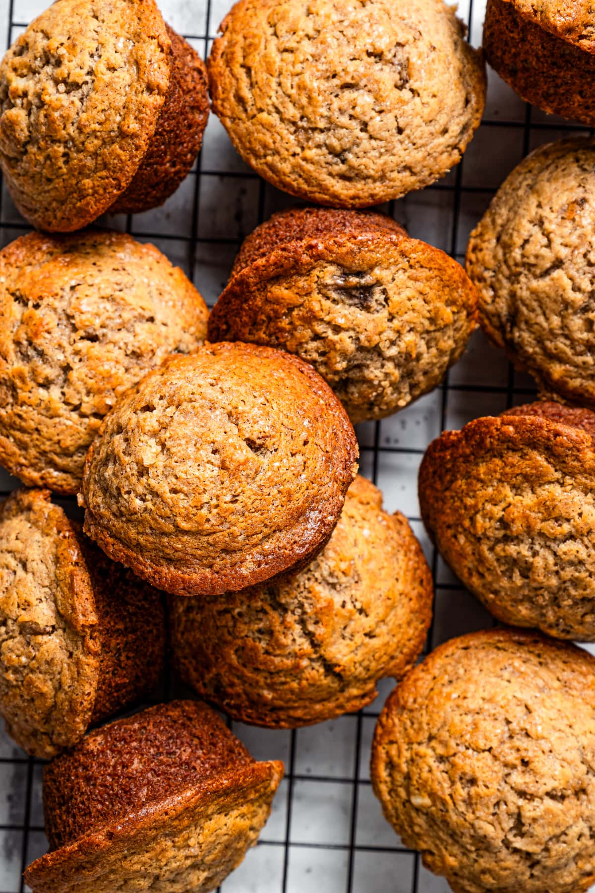 A bunch of banana muffins on a cooling rack.