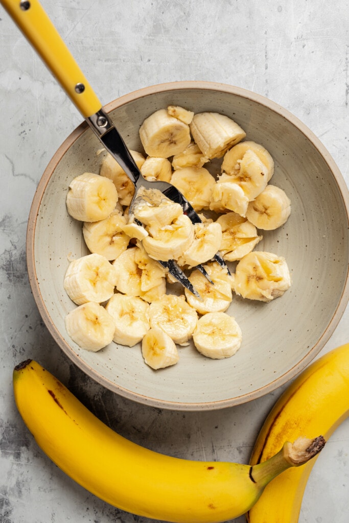 Mashing bananas with a fork.