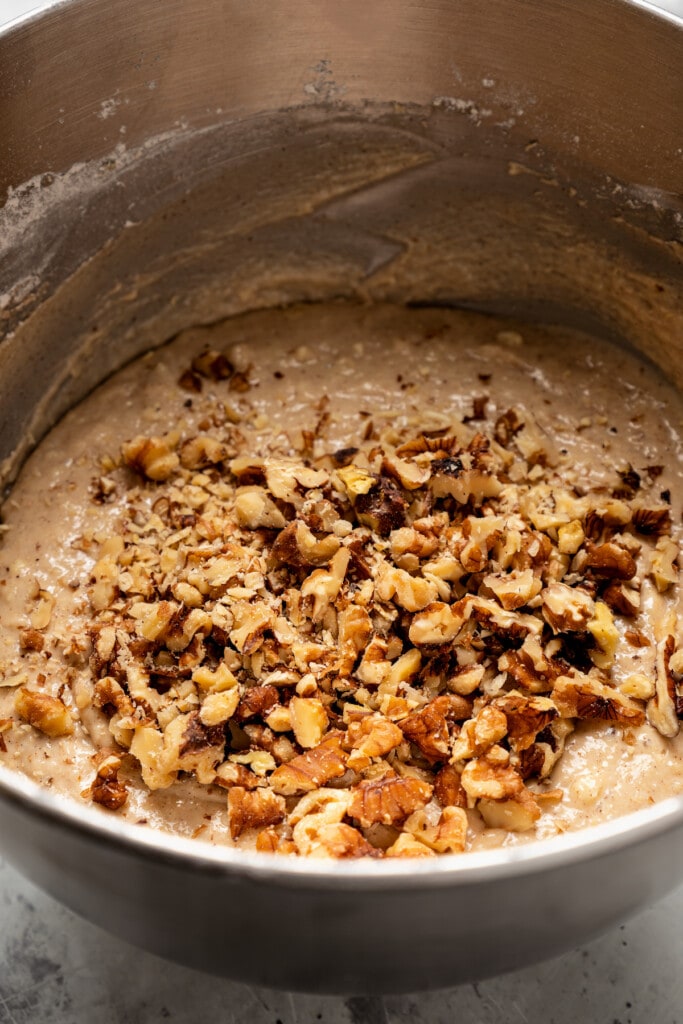 Folding walnuts into banana muffin batter.