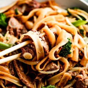 overhead shot of chopsticks rotating beef chow fun.