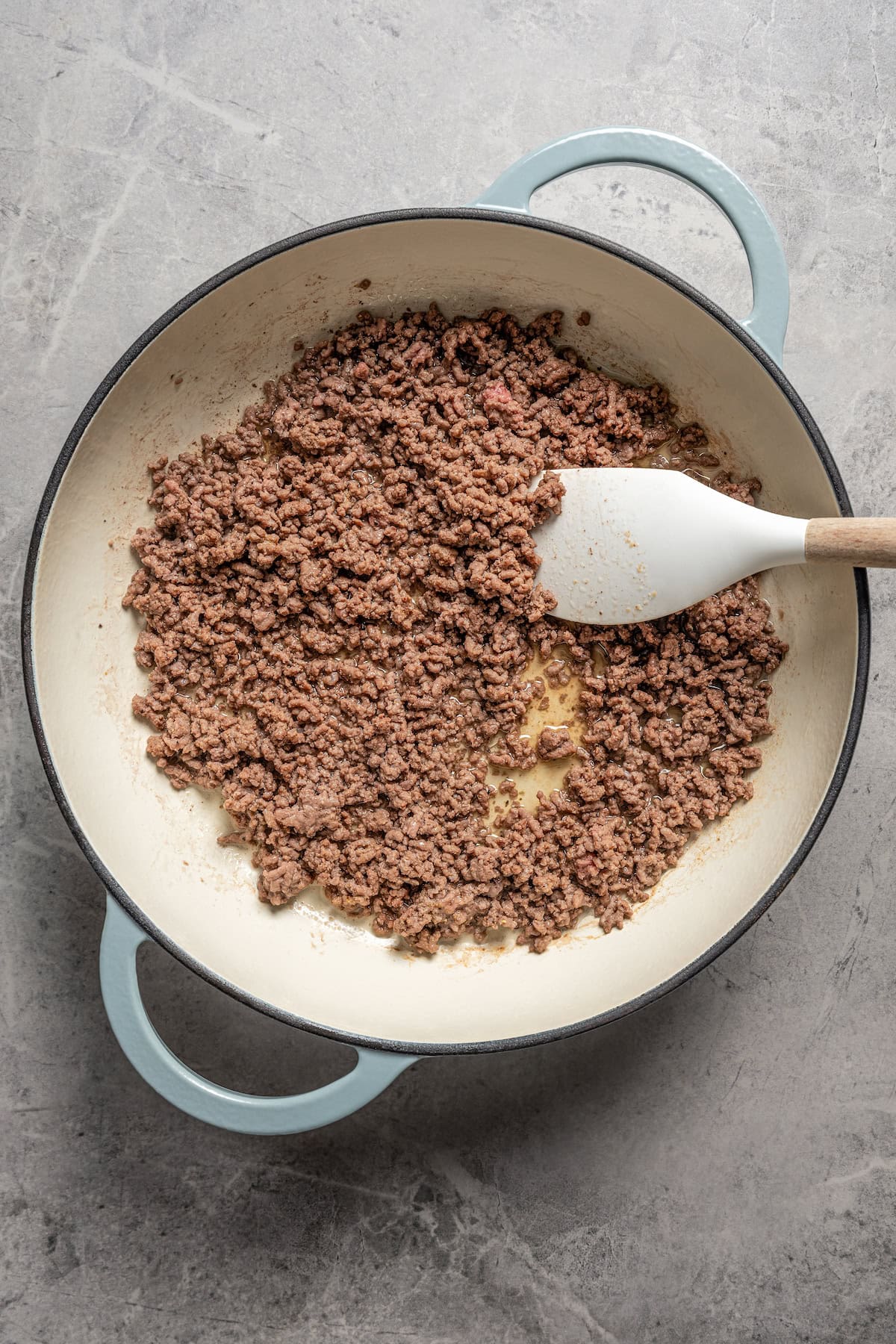 Browed ground beef in a skillet with a spatula.