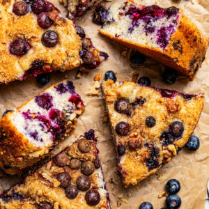 Slices of blueberry cake arranged on brown parchment paper.