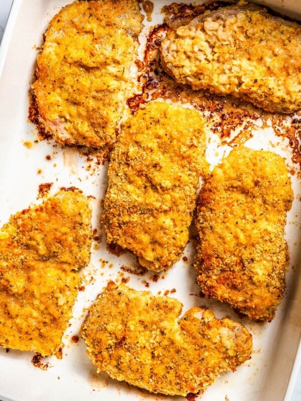 Baked breaded pork chops in a ceramic baking dish.