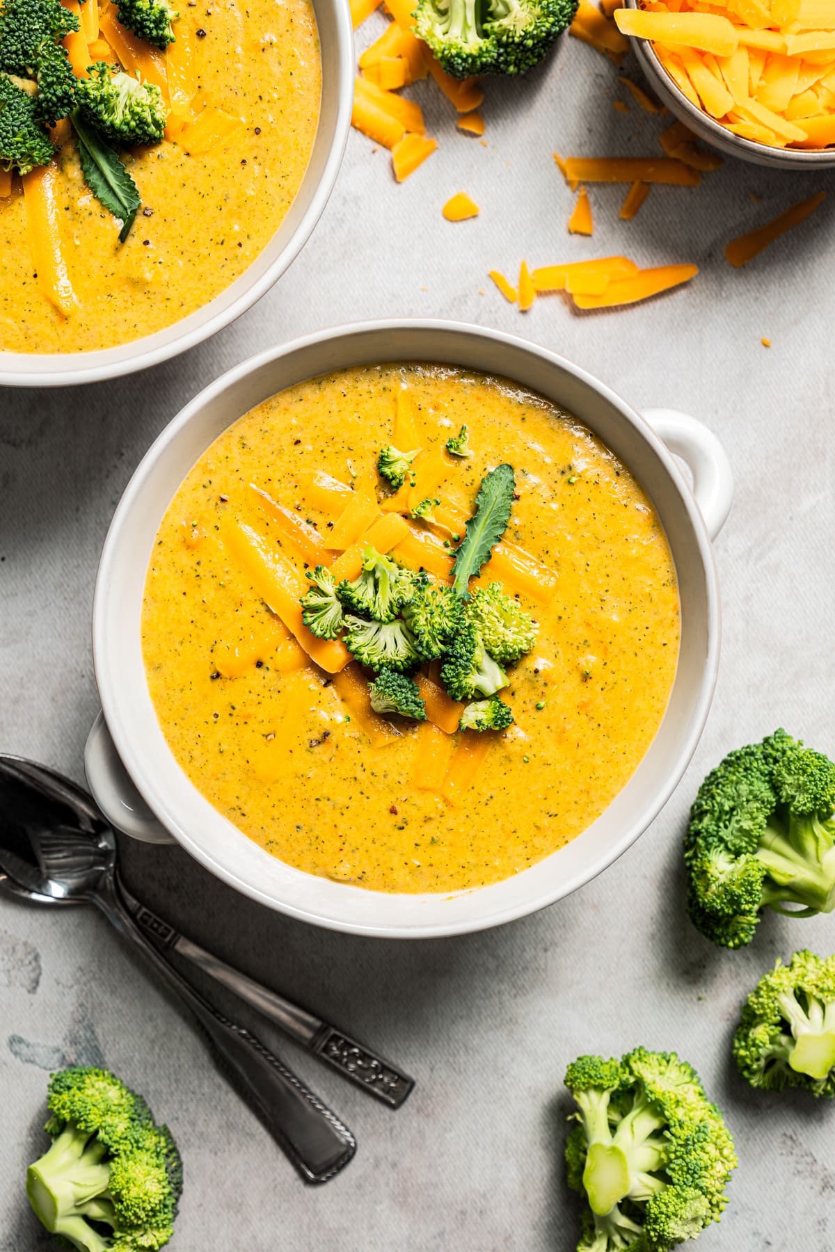 Overhead image of broccoli cheese soup served in bowls.