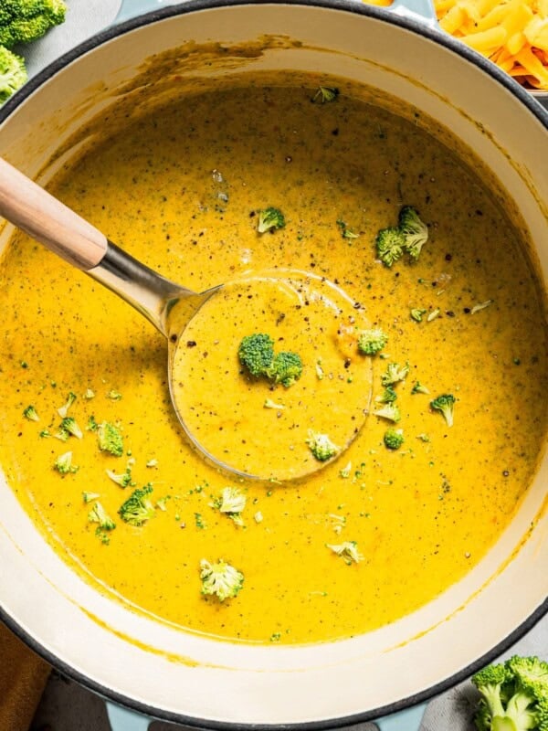 Overhead image of broccoli cheese soup in a soup pot with a ladle.