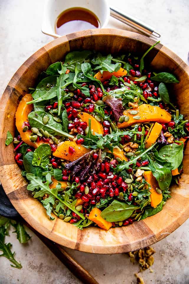 prepping butternut squash salad in a wooden salad bowl