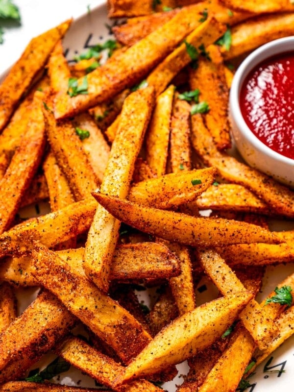 Cajun fries on a serving platter with ketchup.