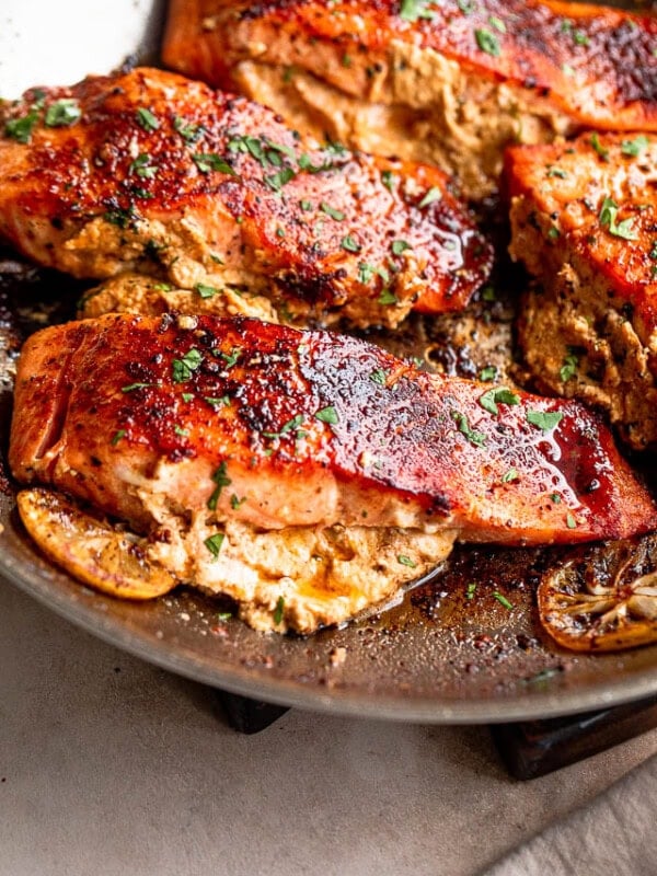 Salmon fillets cooking in a skillet.