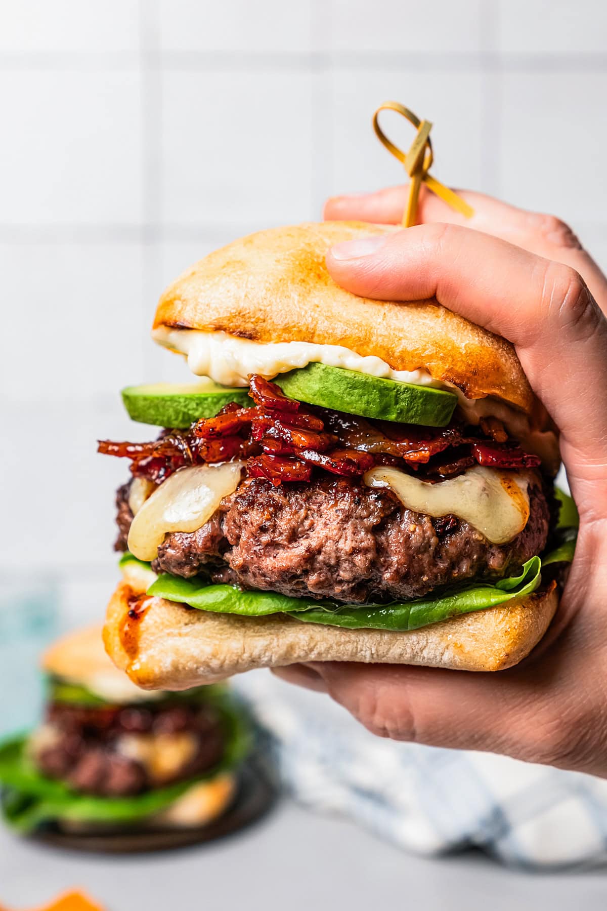 A hand holding up a California burger.