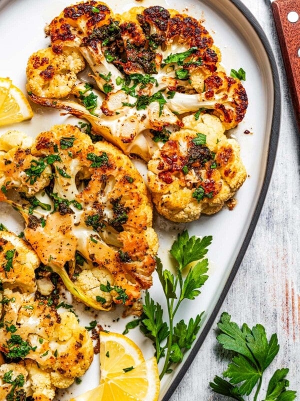 Roasted cauliflower steak on a serving platter.