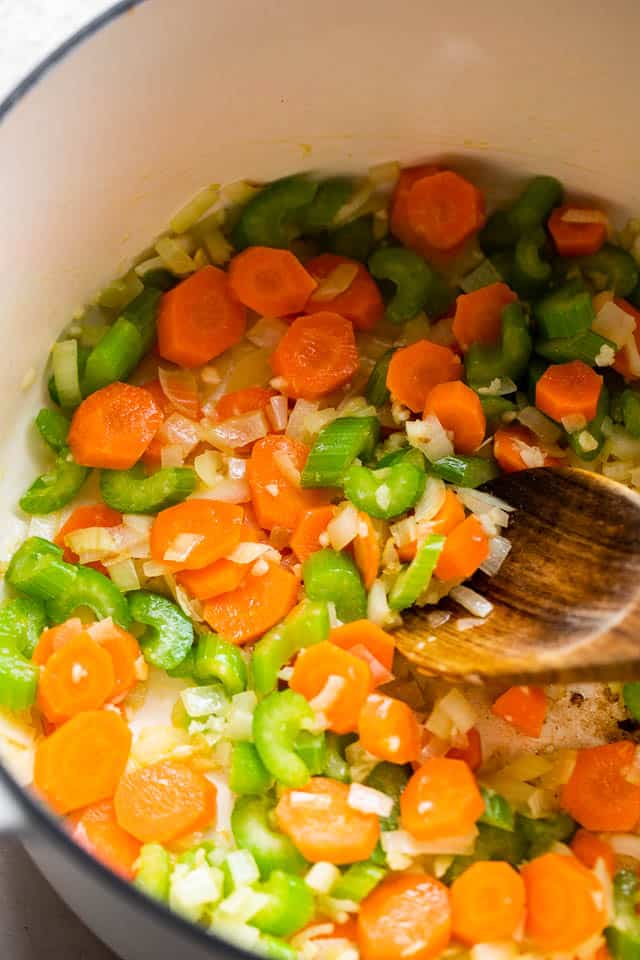 Sauteeing celery and carrots in a Dutch oven.