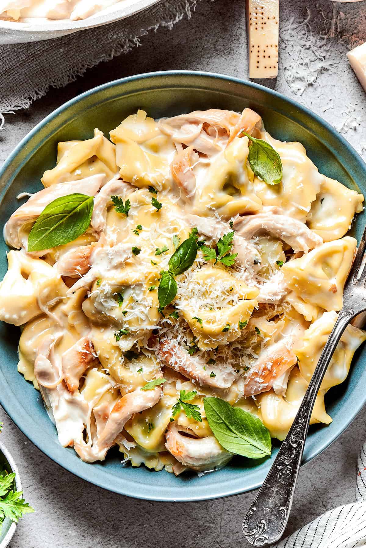 Creamy chicken tortellini served on a dinner plate.