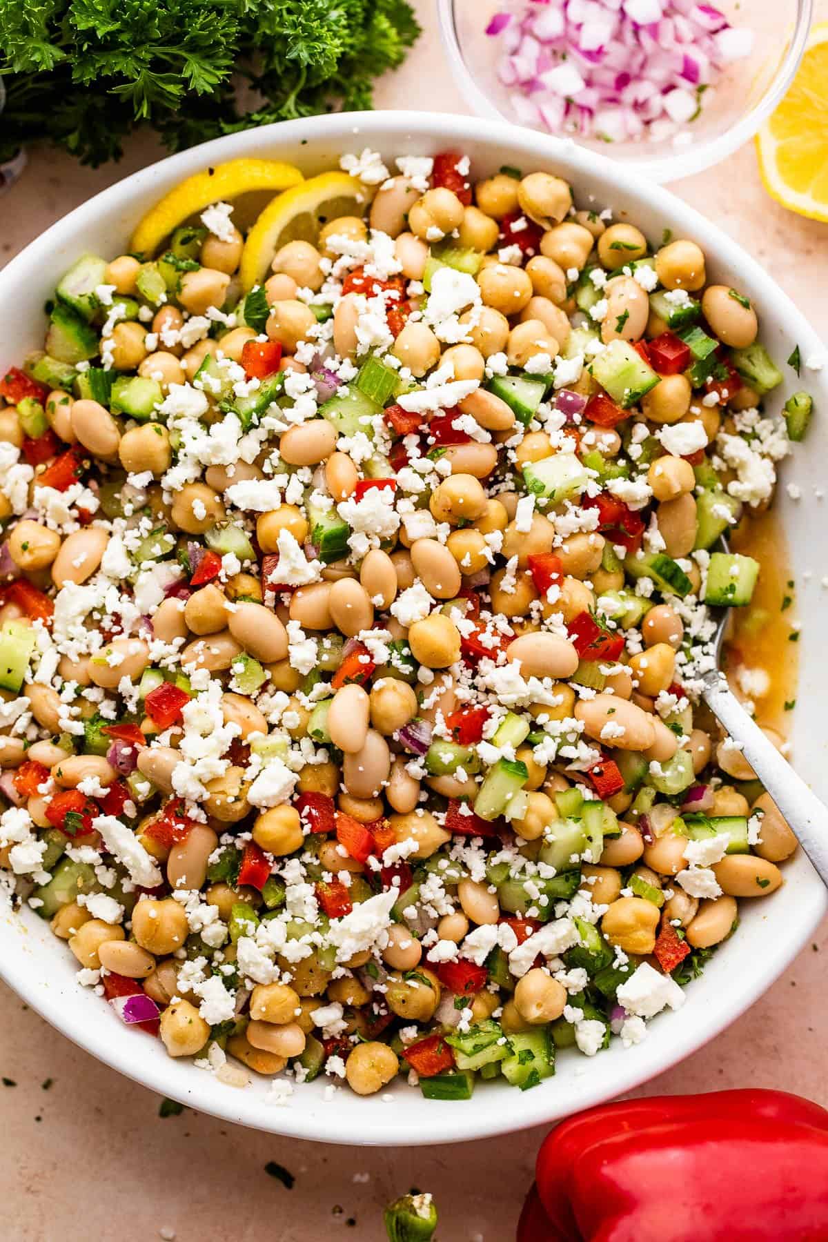 Overhead shot of a salad bowl with a chickpea salad topped with crumbled feta cheese.