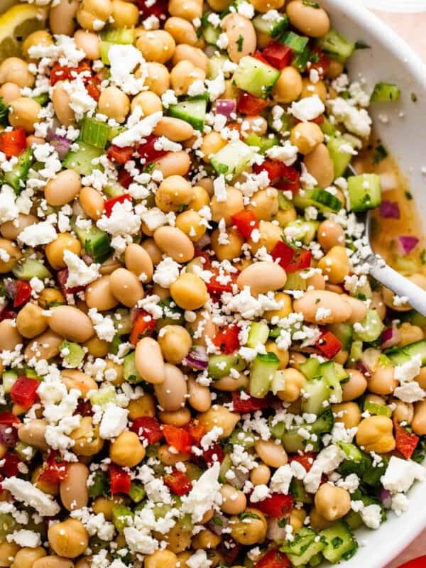 overhead close up shot of a white salad bowl with chickpea salad topped with crumbled feta cheese