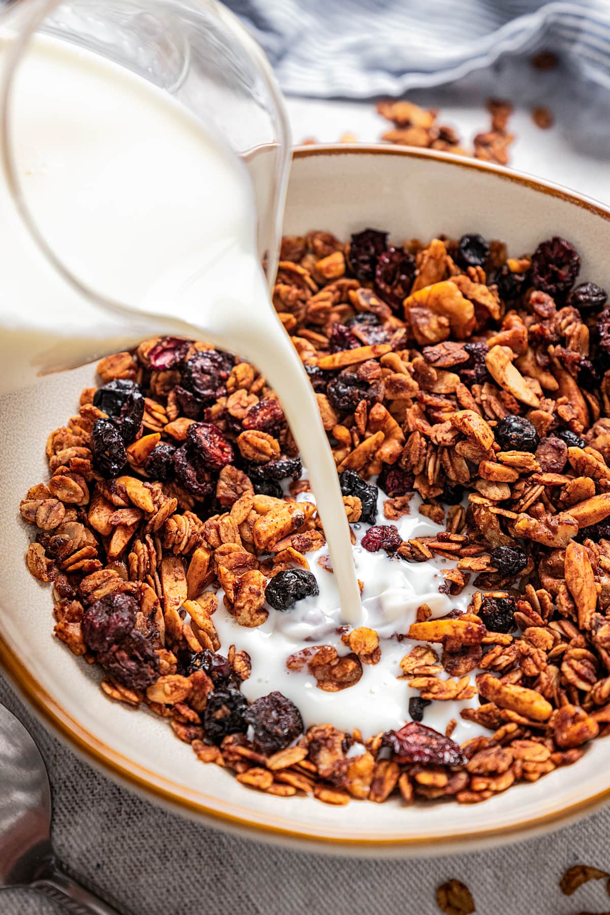 Pouring milk into a bowl of granola.