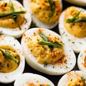 side shot of deviled eggs set on a black plate.