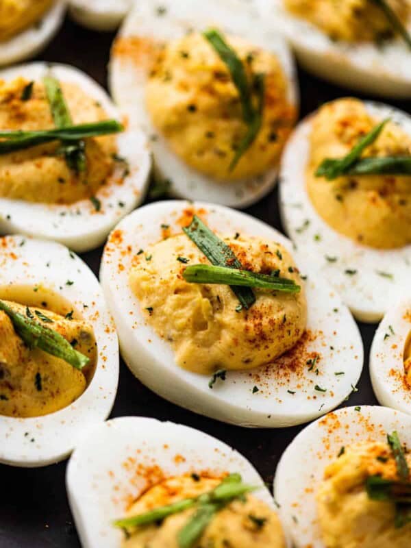 side shot of deviled eggs set on a black plate.