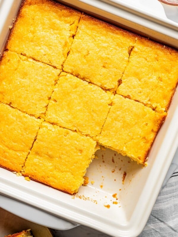 Sliced cornbread casserole in a baking pan.