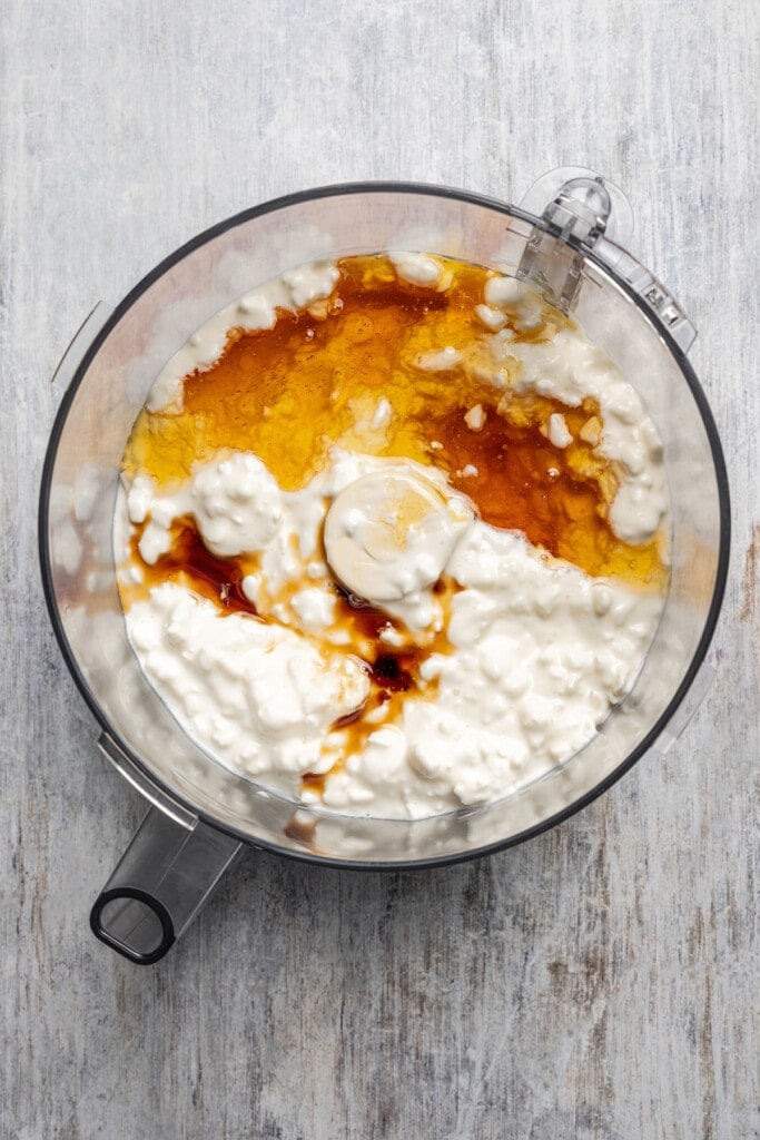 Adding cottage cheese, vanilla, and honey to a blender.