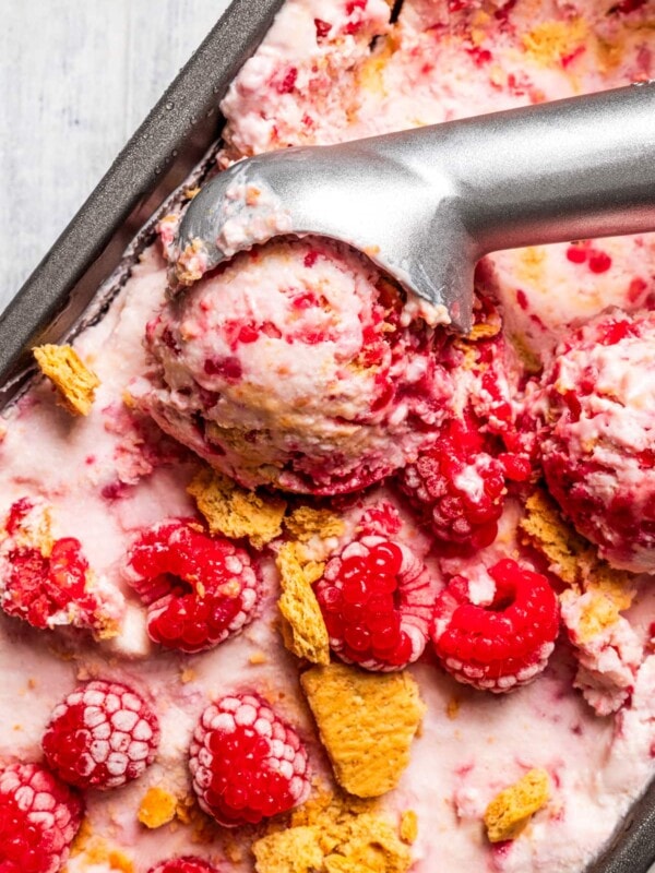 Taking a scoop of raspberry cottage cheese ice cream out of a loaf pan.