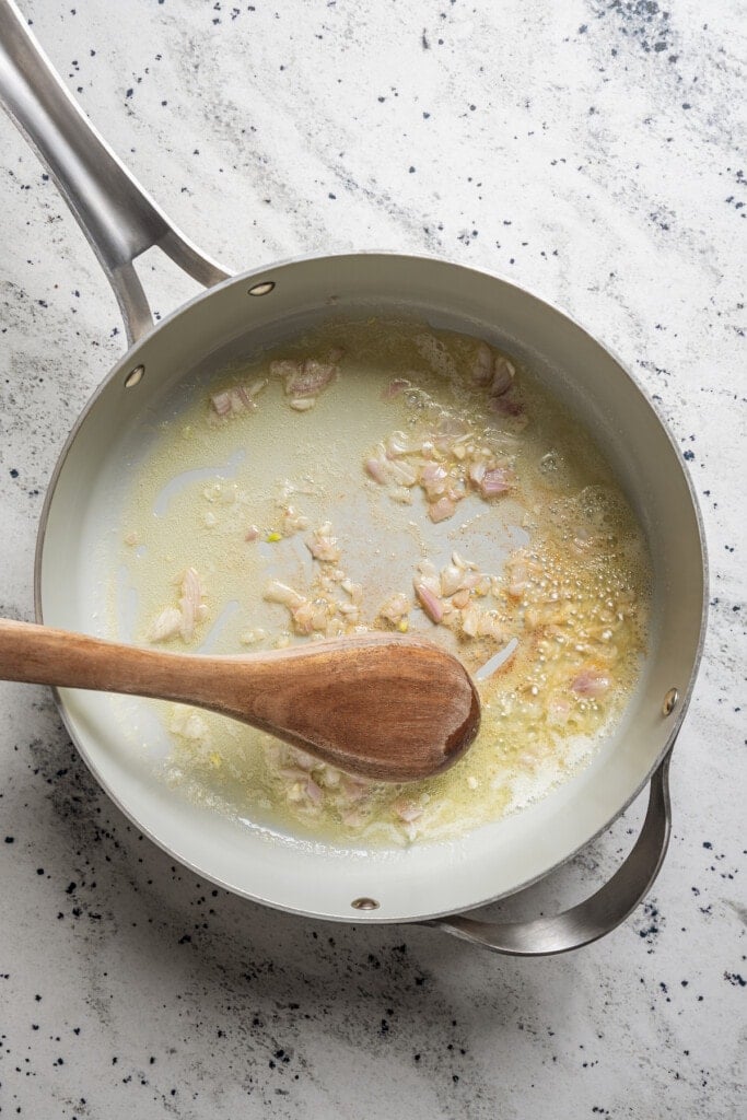 Sauteing chopped shallot in butter.