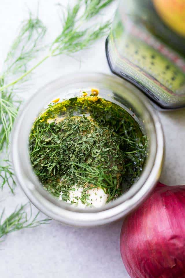 Chopped dill and plain yogurt in a bowl prepped for a homemade salad dressing.