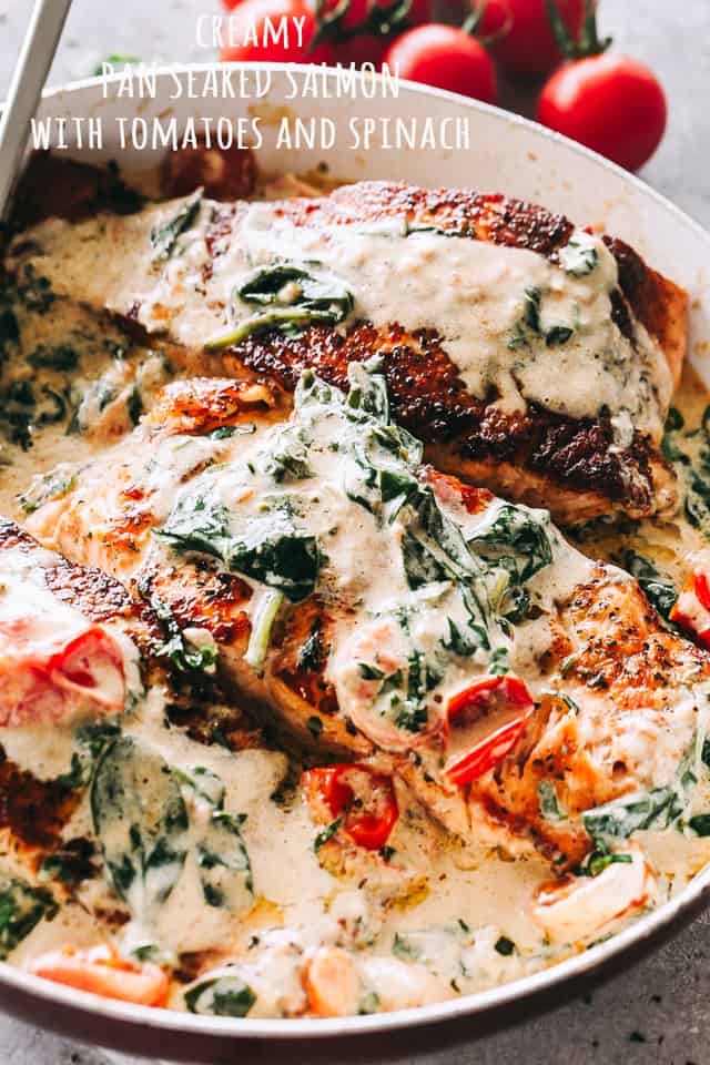 Pan seared salmon fillets in a cream sauce with tomatoes and baby spinach.