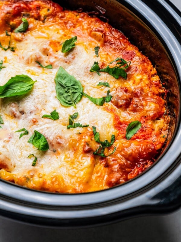 Cooked lasagna in a slow cooker insert.