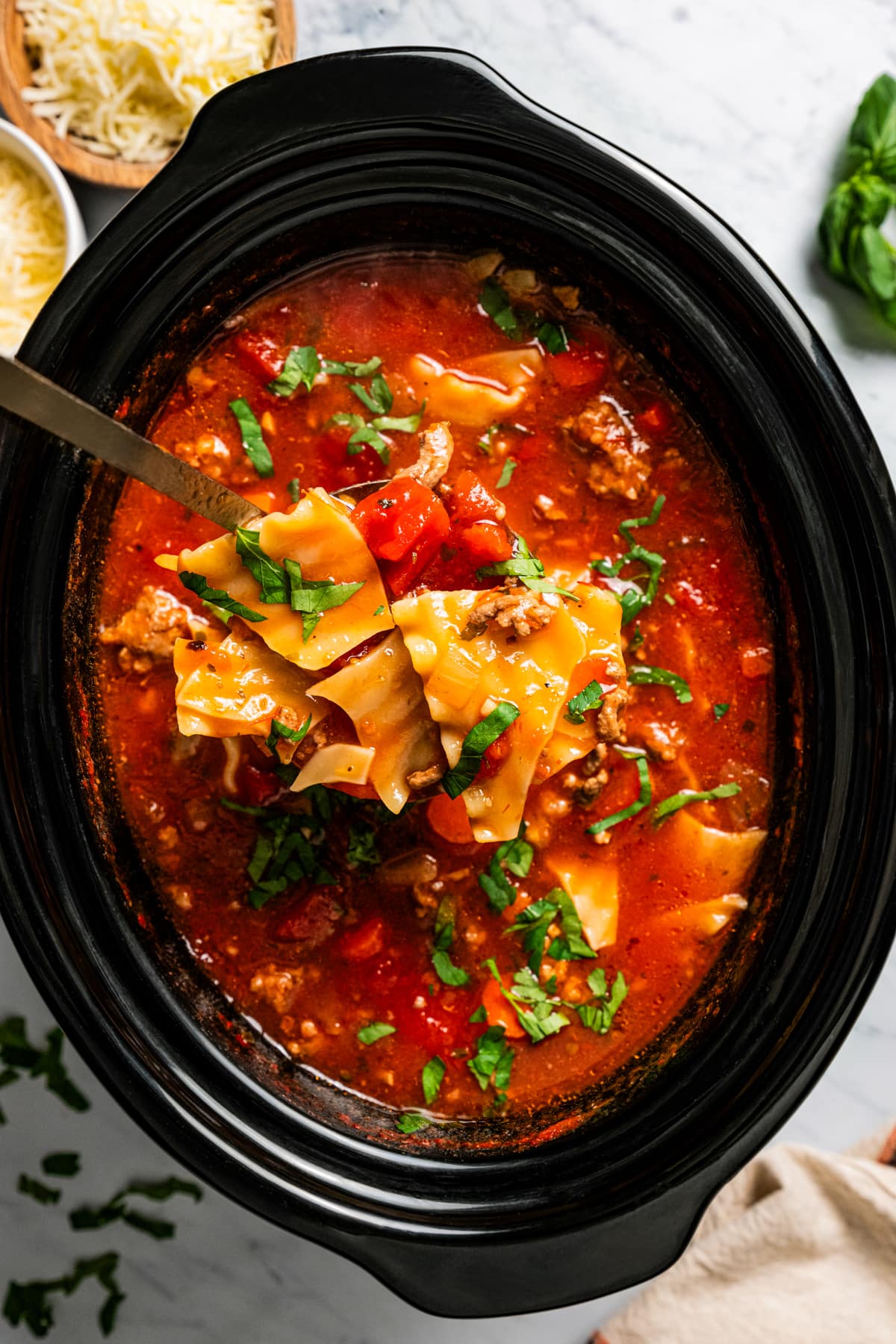 Ladling soup out of the slow cooker.