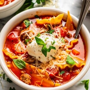 Closeup of lasagna soup in a bowl topped with ricotta.