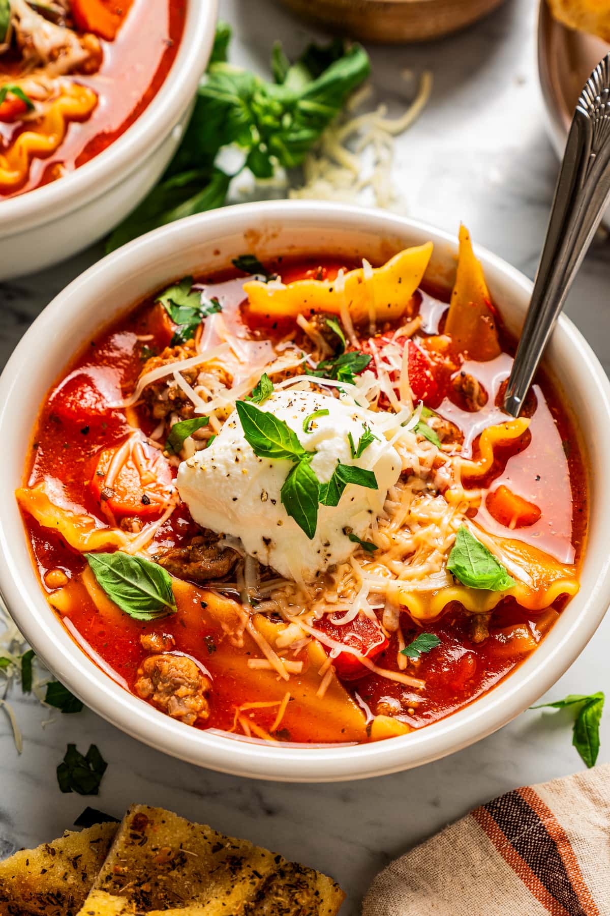 Closeup of lasagna soup in a bowl topped with ricotta.