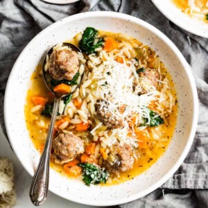 Bowl of Italian wedding soup with parmesan.