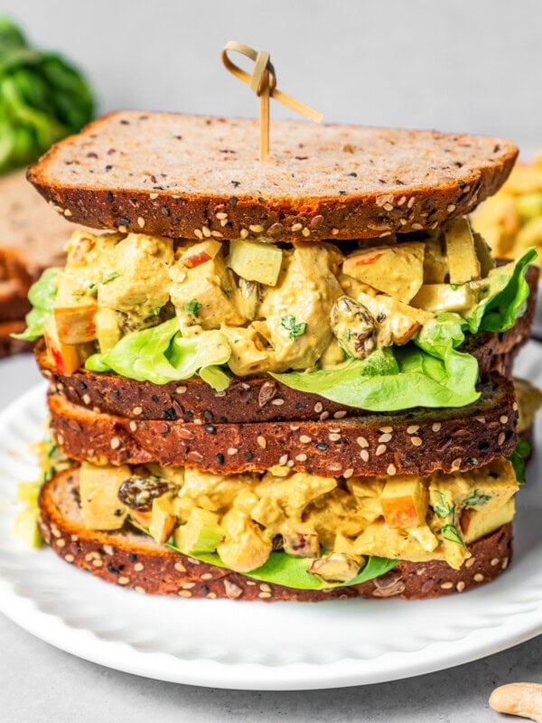 Piled-up curry chicken salad sandwich with chopped chicken, celery, apples, and more.