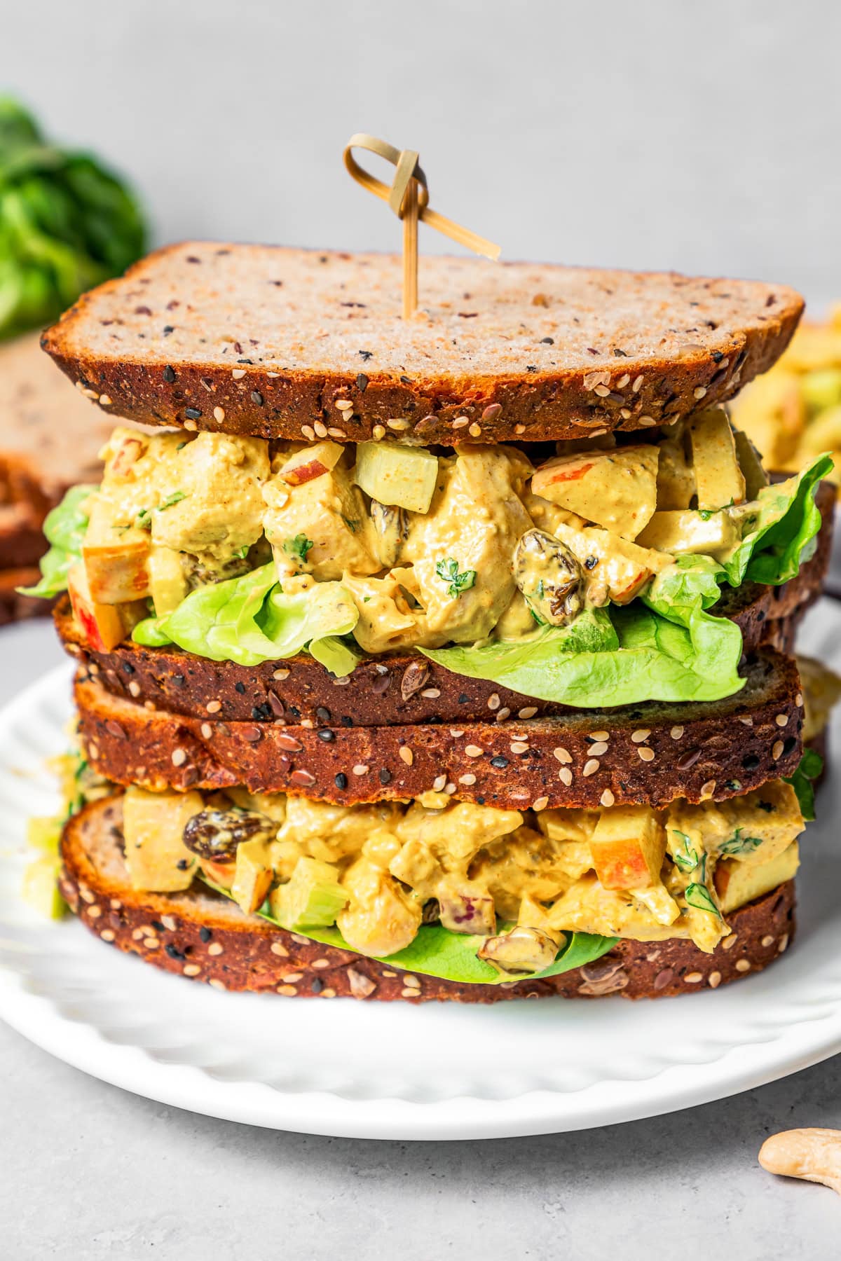 Piled-up curry chicken salad sandwich with chopped chicken, celery, apples, and more.