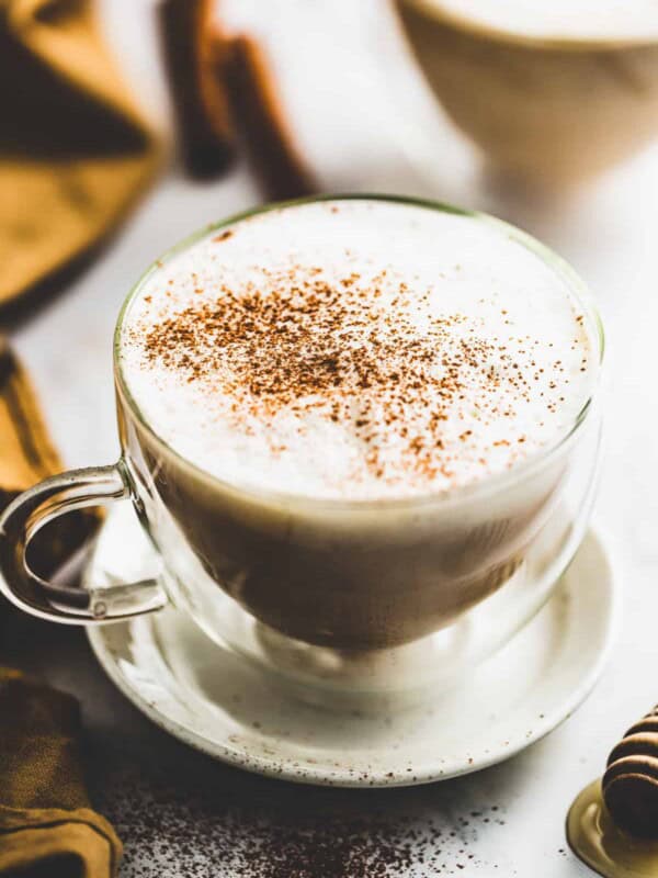 Angled shot of dirty chai latte in a glass mug.