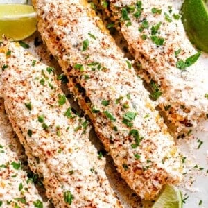 ELOTE corn served on a platter with lime wedges