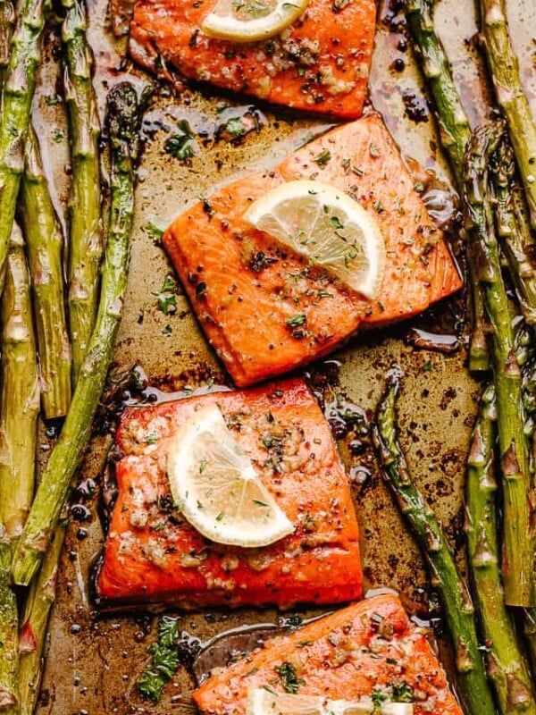 roasted sockeye salmon fillets topped with lemon slices and asparagus spears on either side