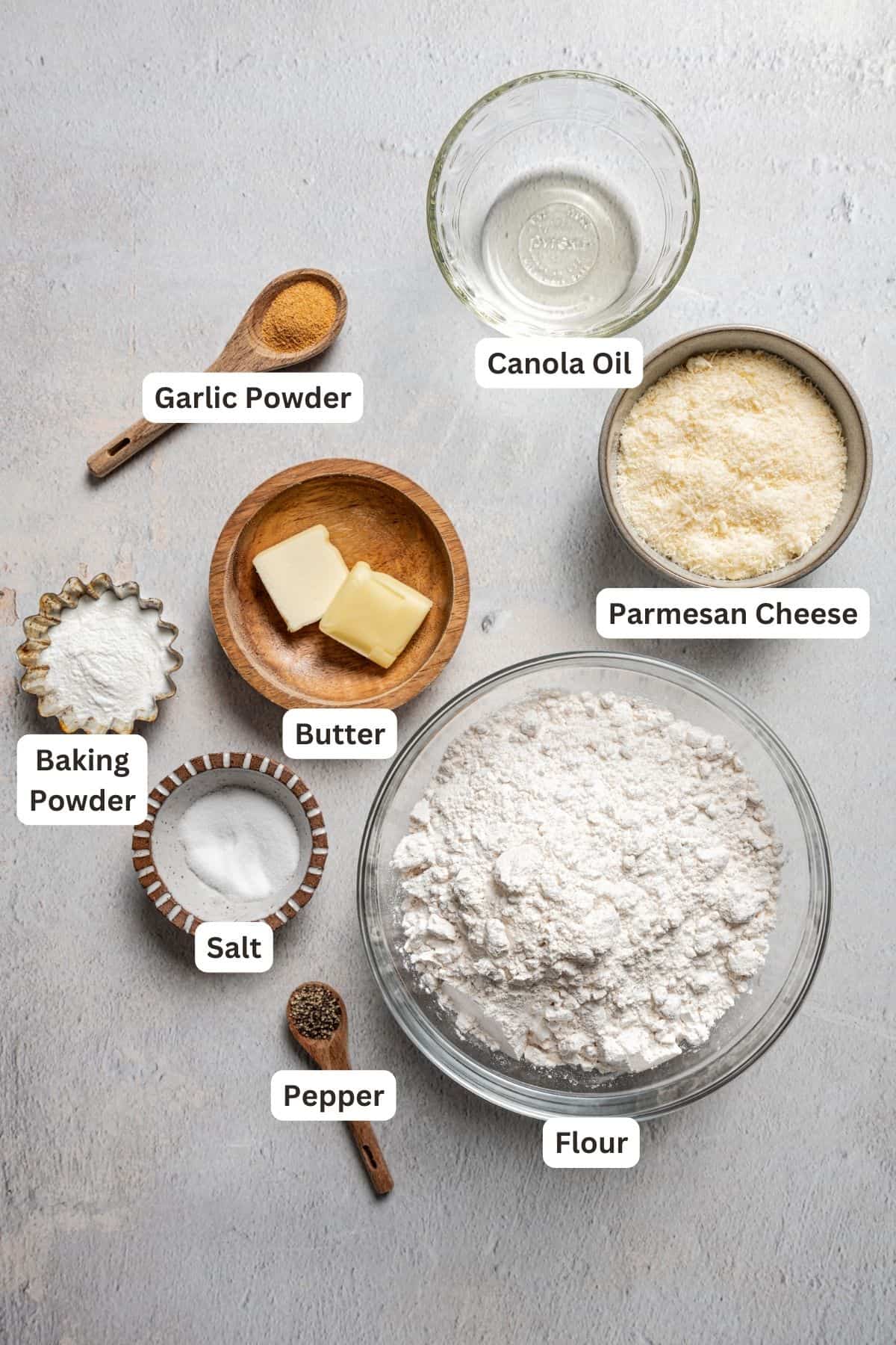 Ingredients for homemade garlic parmesan breadsticks with text labels overlaying each ingredient.